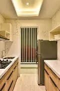 Modern kitchen area with marble flooring and stainless steel appliances